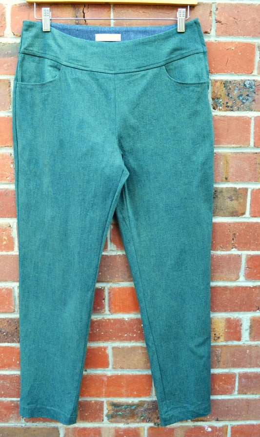 Green pants hanging on a brick wall