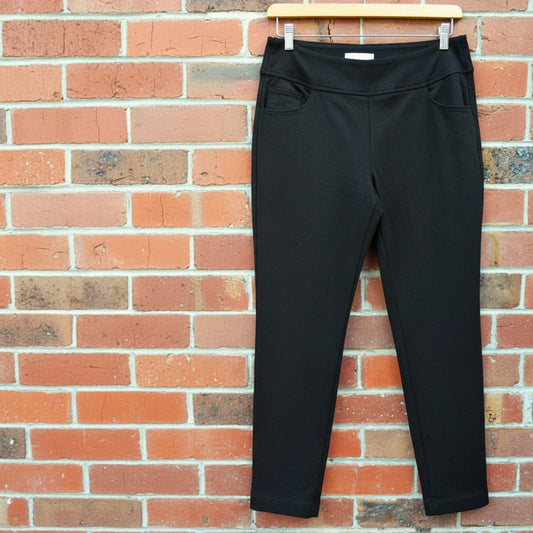 Green pants hanging on a brick wall
