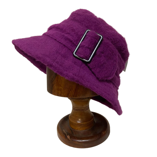 Purple hat with a buckle on a wooden mannequin head against a neutral background