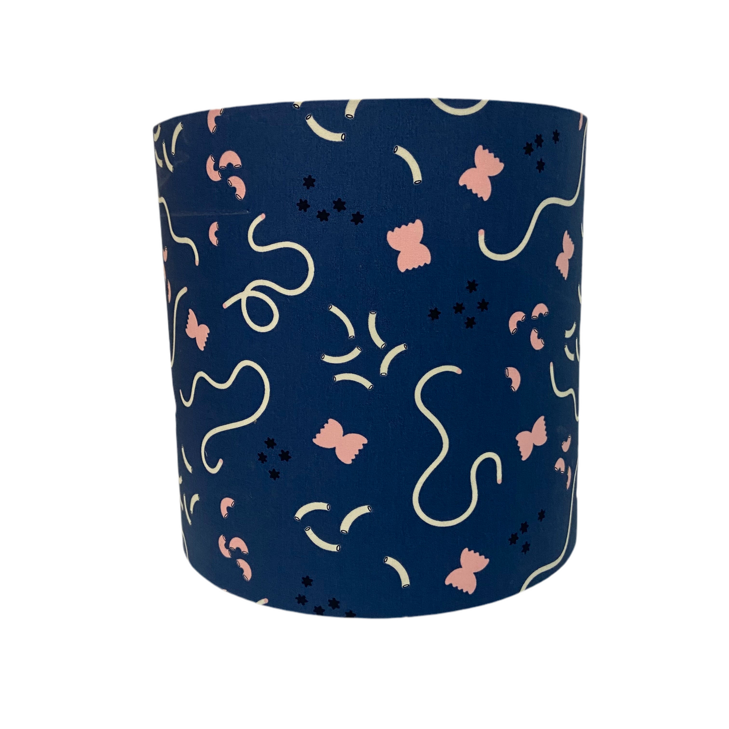 Navy blue cylindrical lampshade with pink and white abstract patterns of pasta and macaroni on a white background