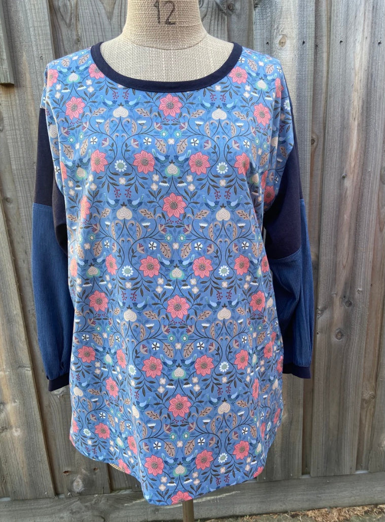 Floral tunic top on a mannequin against a wooden background