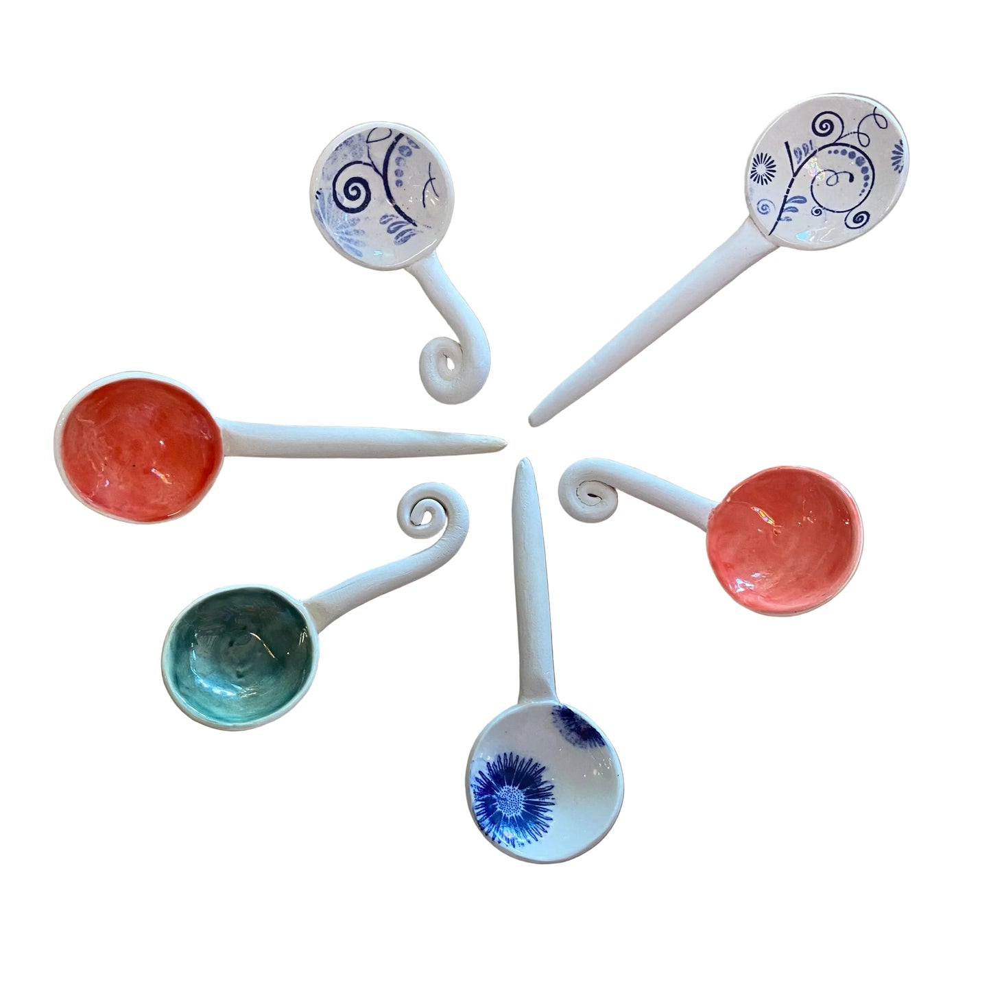 Set of ceramic spoons with decorative handles on a wooden surface