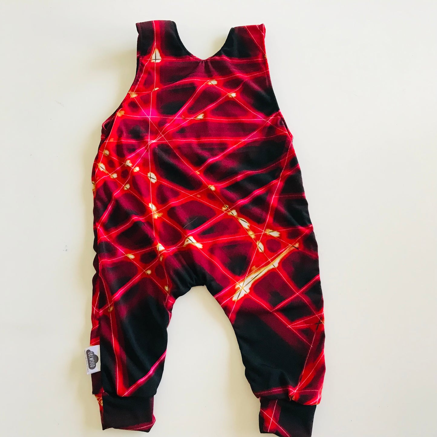 Red and black patterned romper on a white background