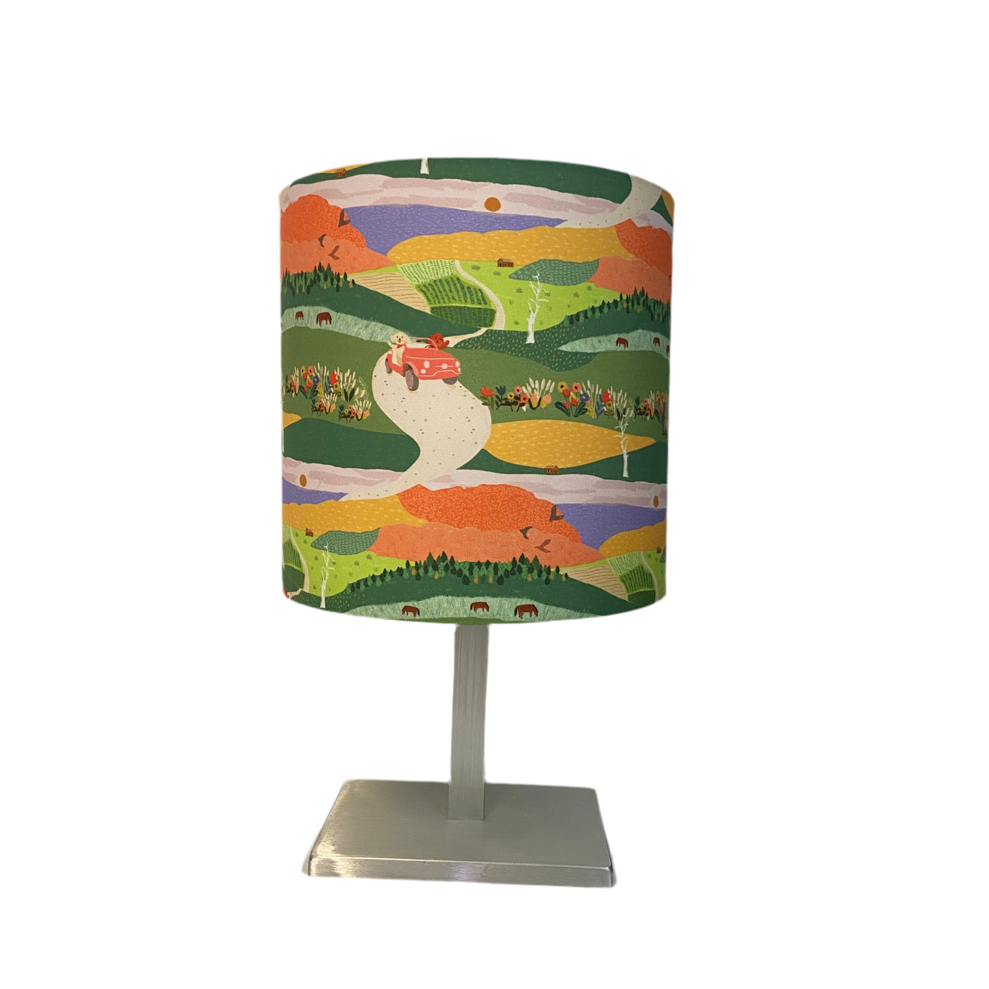 Table lamp with a colorful landscape design on the shade against a white background