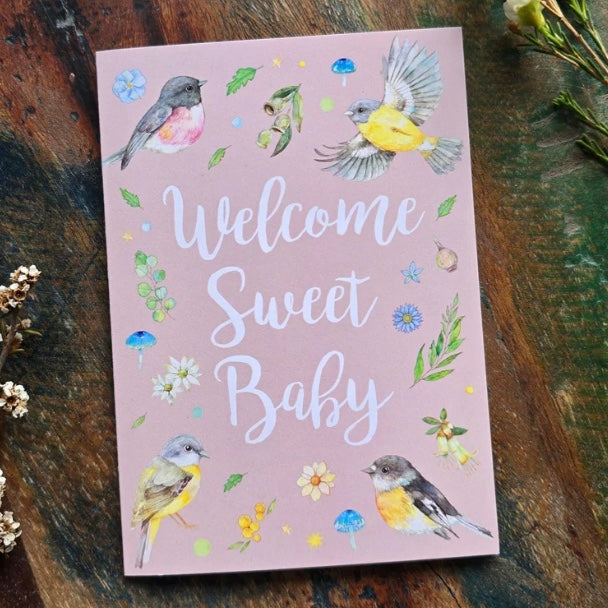 Greeting card with birds and flowers on a wooden surface