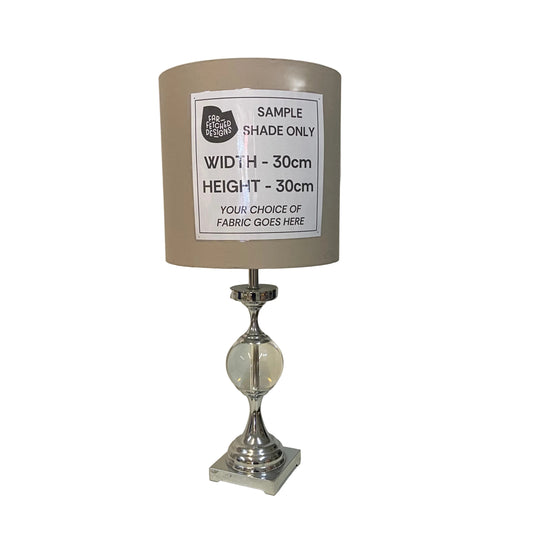 Lamp with a sample shade label on a white surface.
