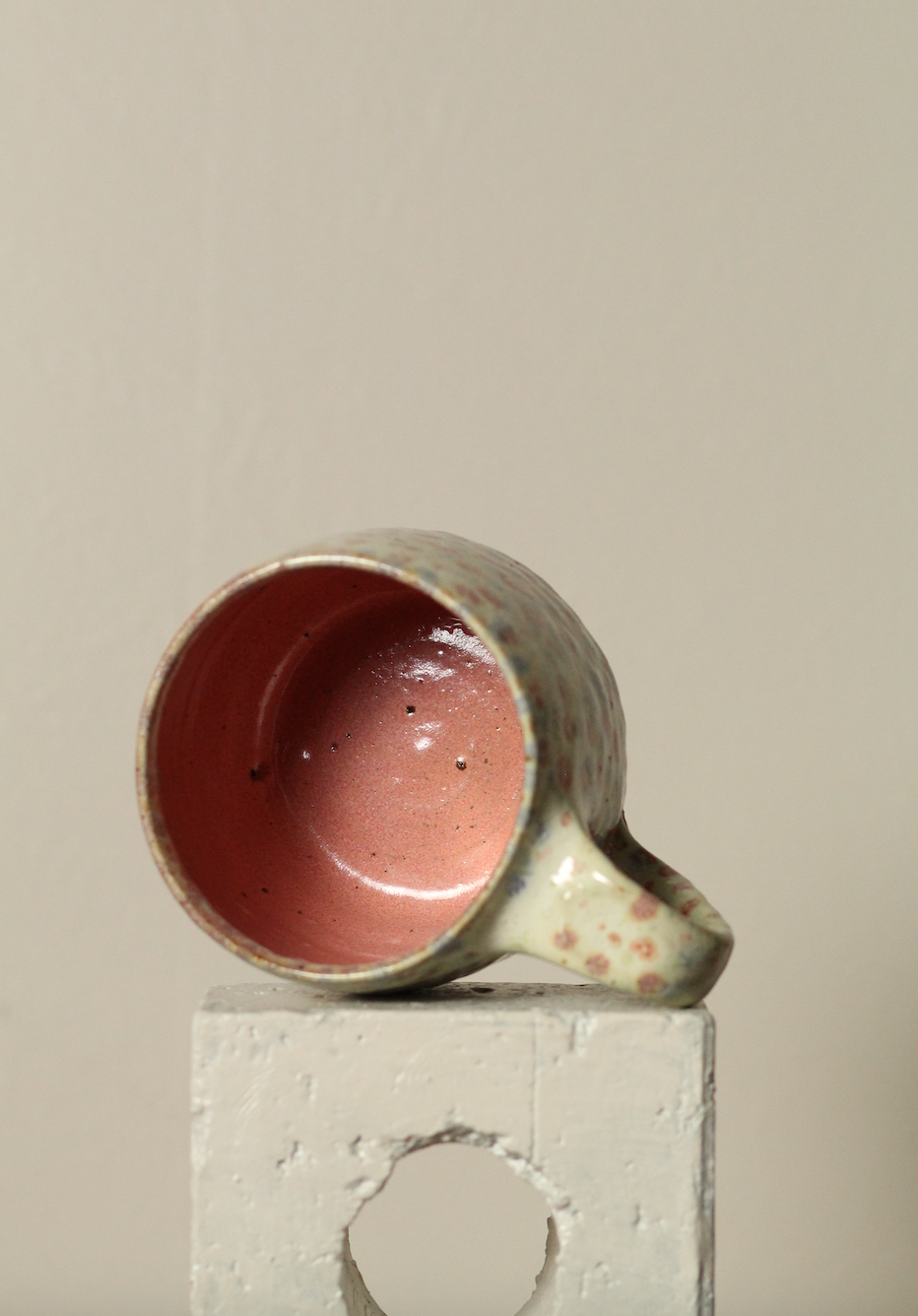 Ceramic cup with a pink interior on a neutral background