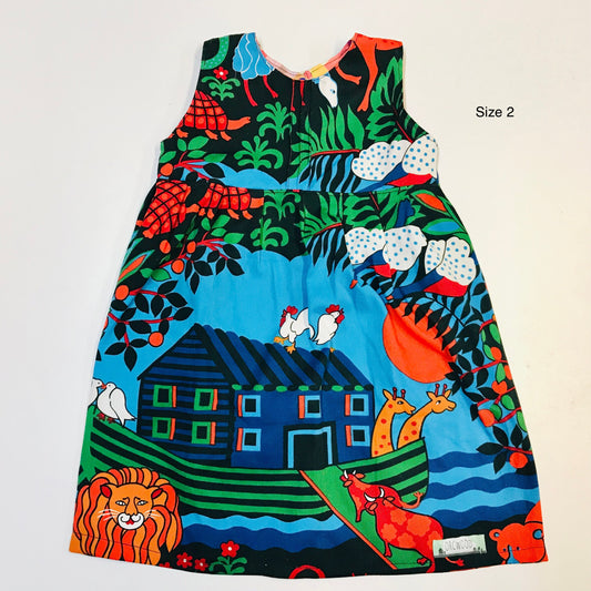 Colorful children's dress with animal and house pattern on a plain background