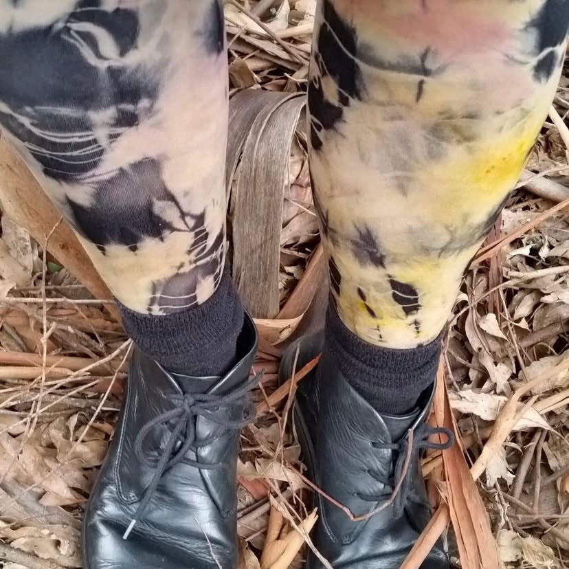 Black leather boots with black and yellow patterned leggings on a natural background