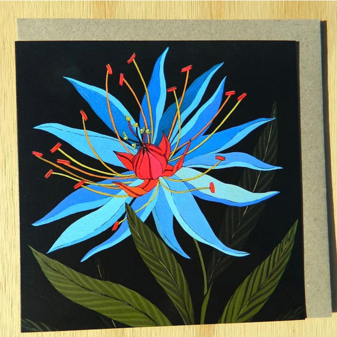 Greeting card with a blue and red flower design on a black background