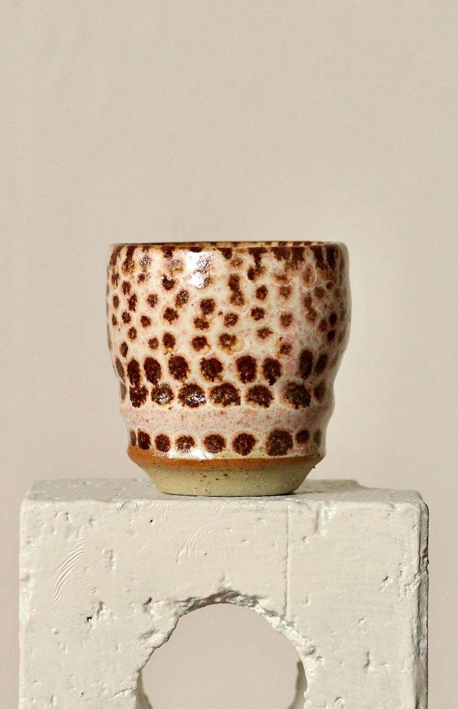 Ceramic cup with brown pattern on a light gray surface