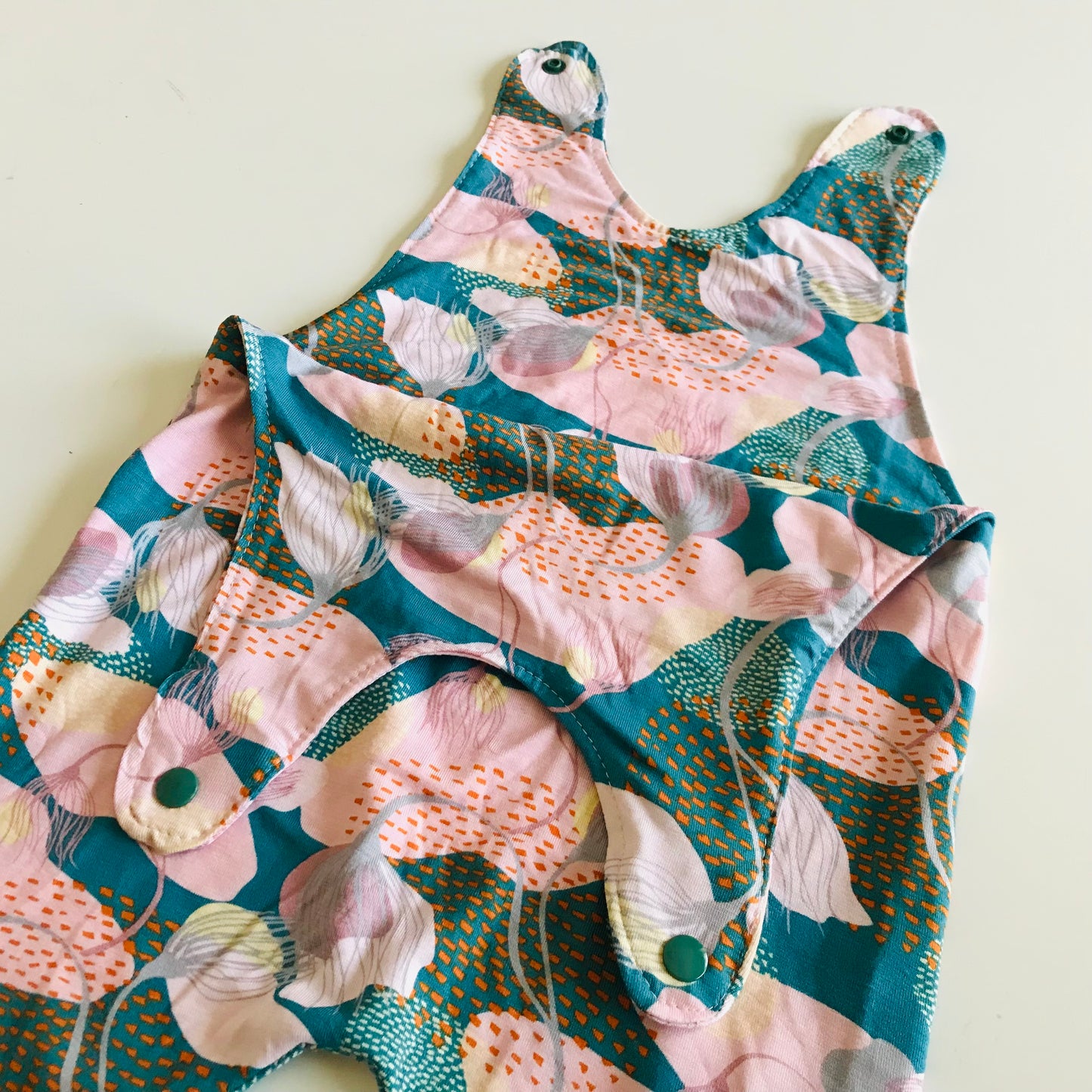 Floral-patterned baby romper on a light background