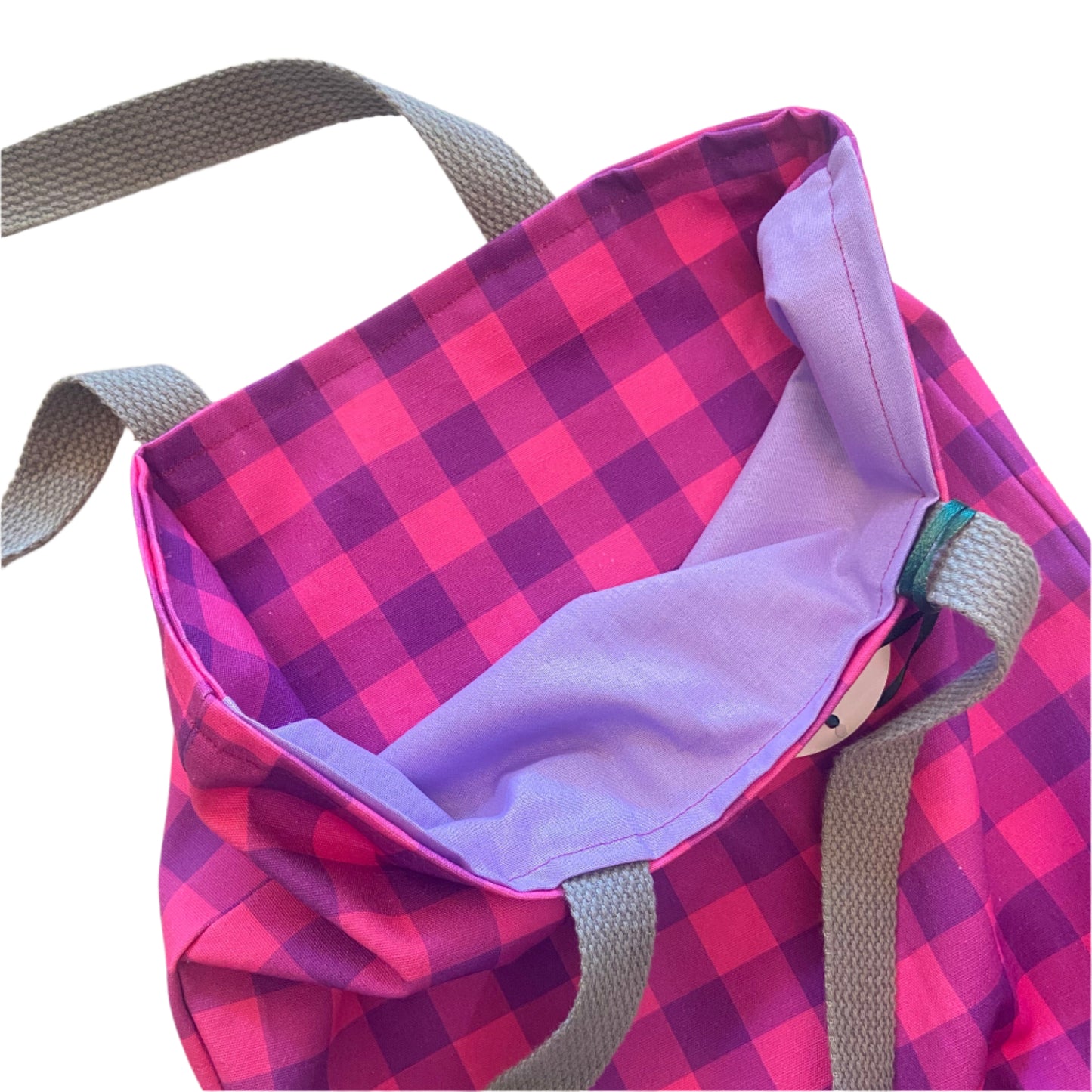 Purple and pink checkered bag with gray straps on a light background