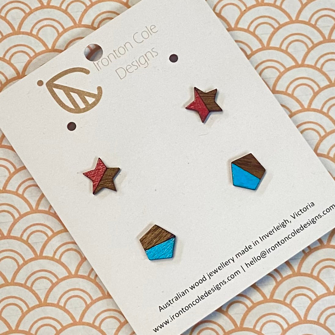 Wooden earrings on a branded card with a decorative background