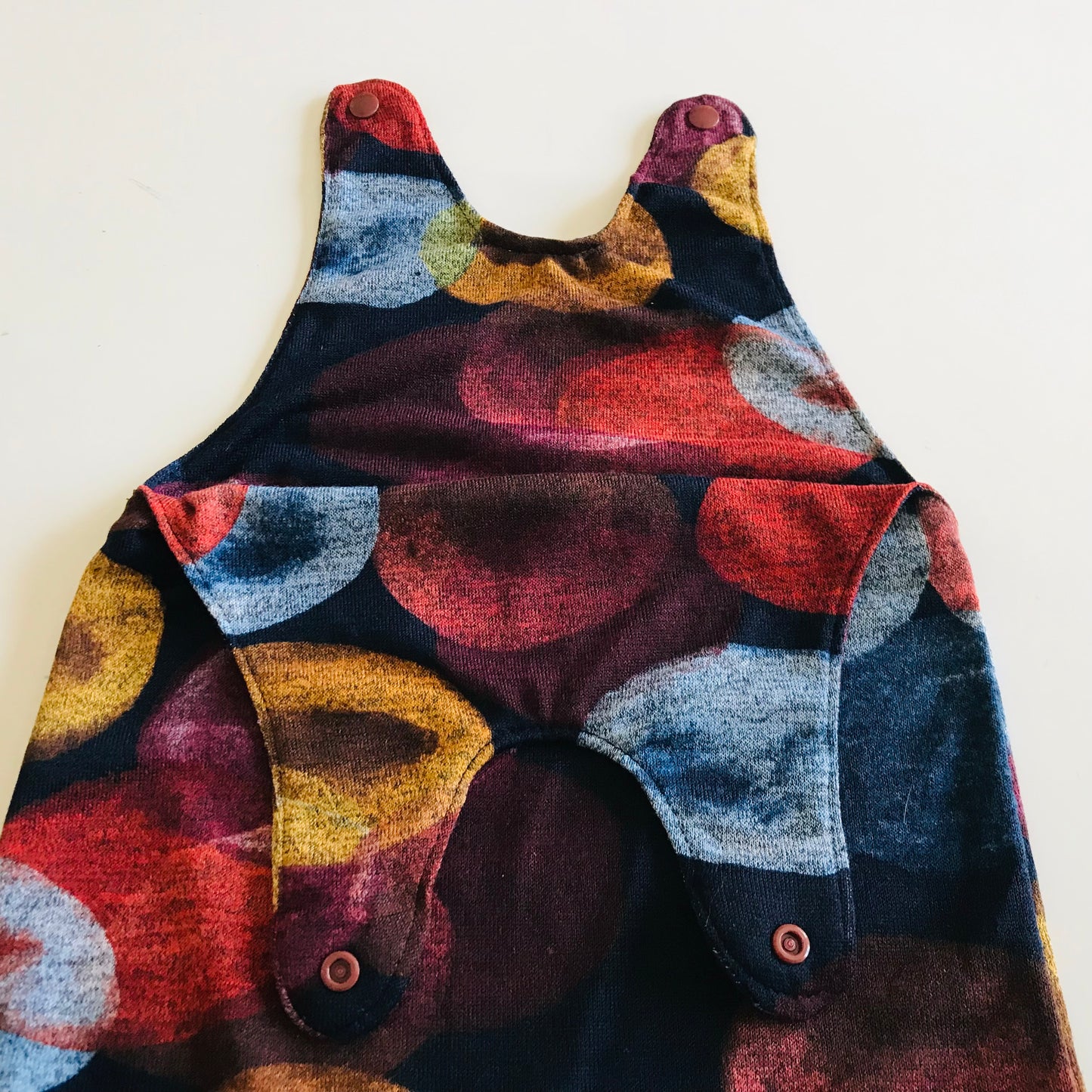 Colorful patterned baby romper on a white background