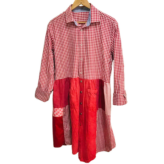 Red and white checkered dress on a hanger against a plain wall