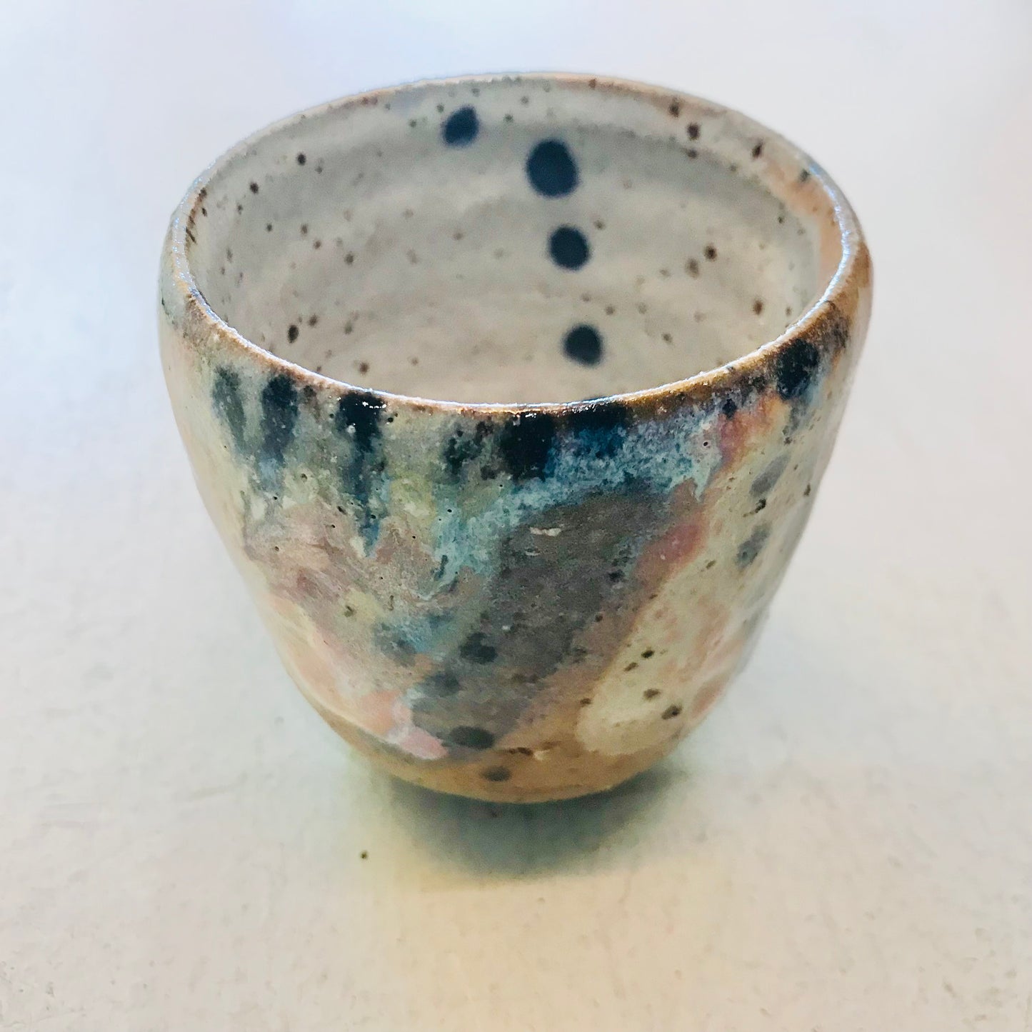 Speckled ceramic cup on a white background