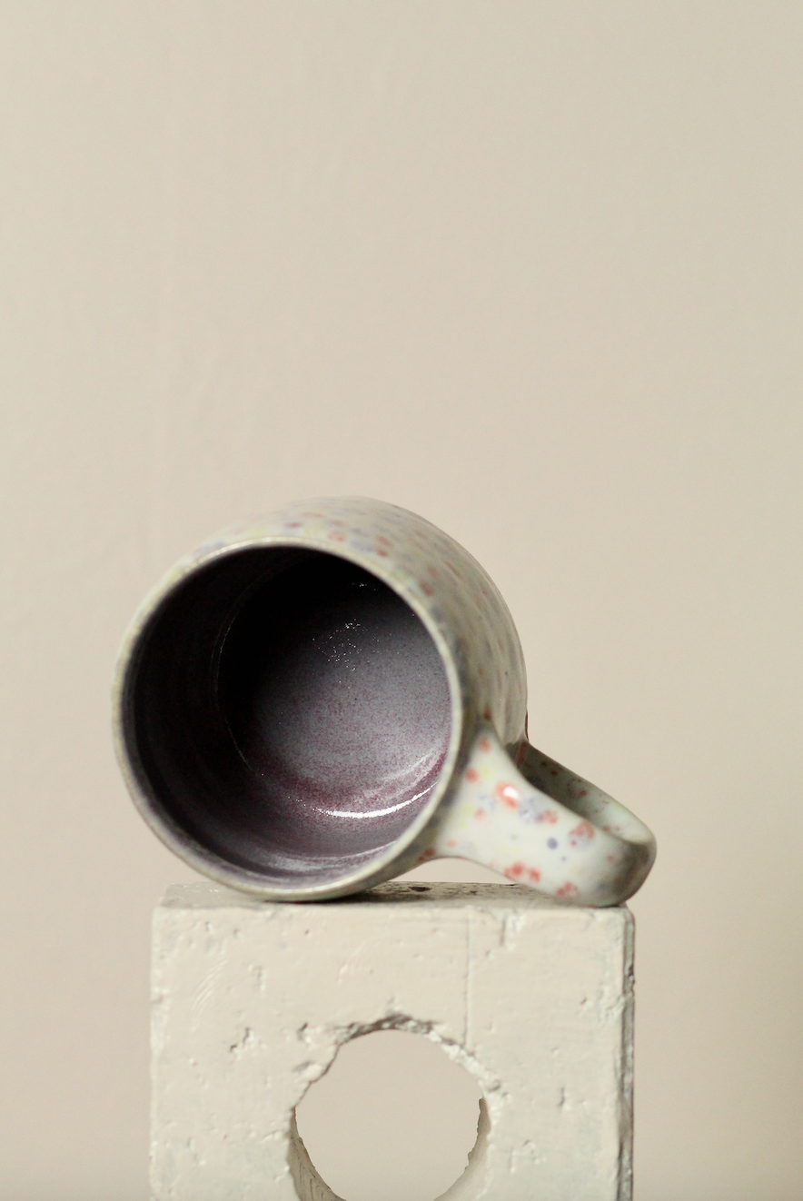Ceramic mug with spotty patterns on a beige background