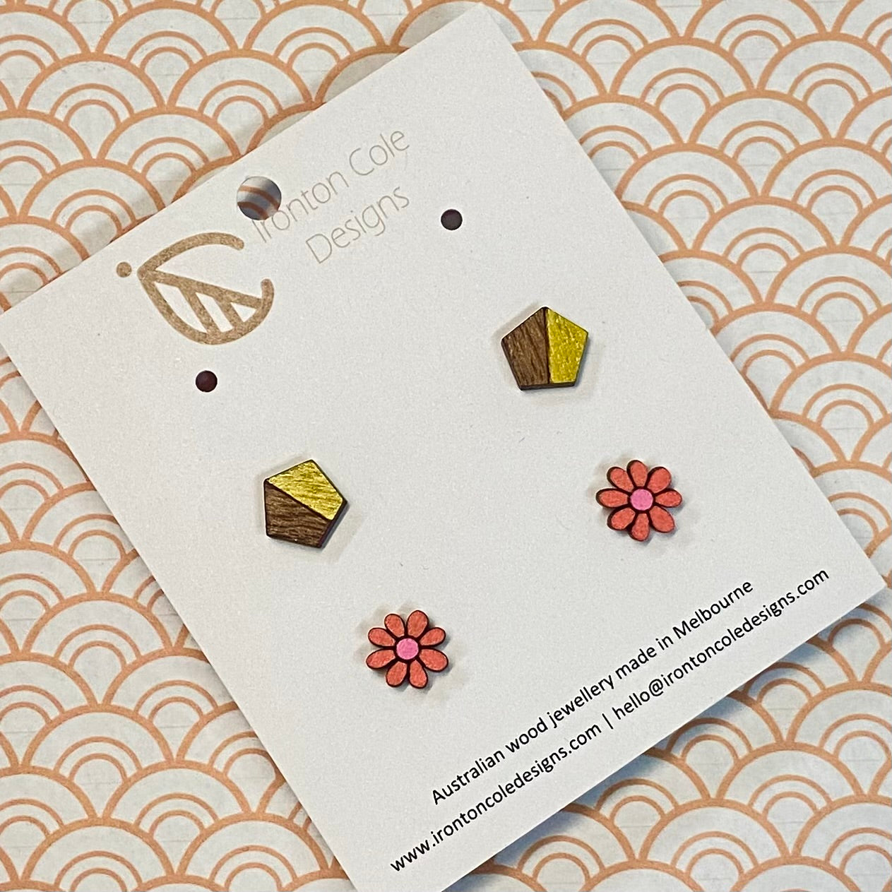 Wooden earrings on a branded card with a decorative background
