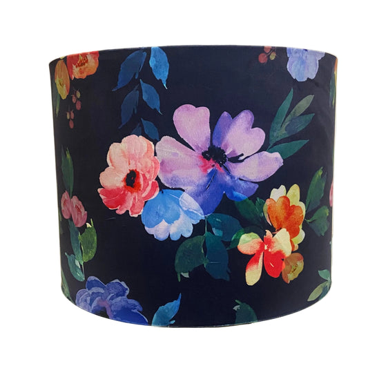 Floral-patterned lampshade on a shelf with a white cabinet in the background