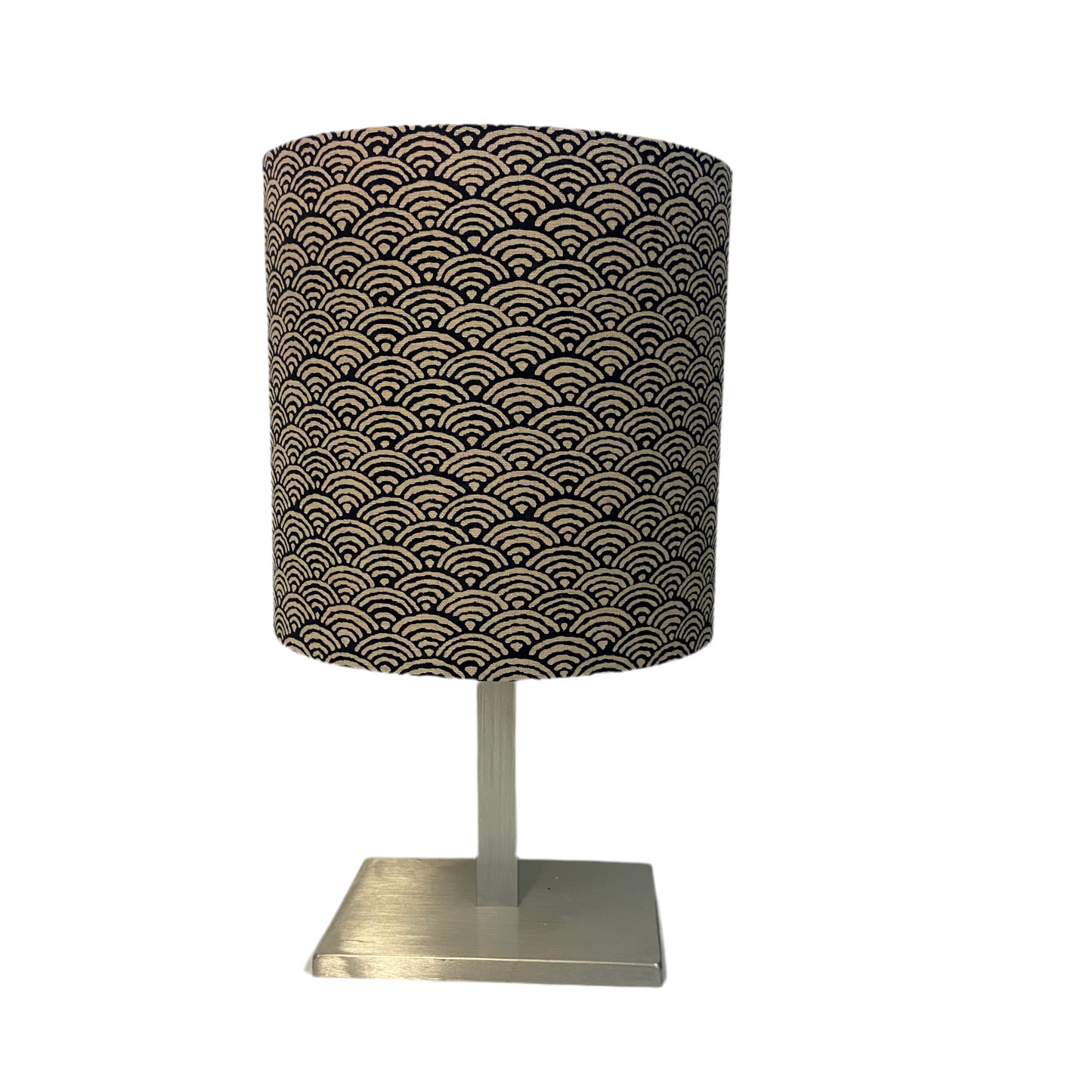 Table lamp with a black patterned shade and metallic base on a white background