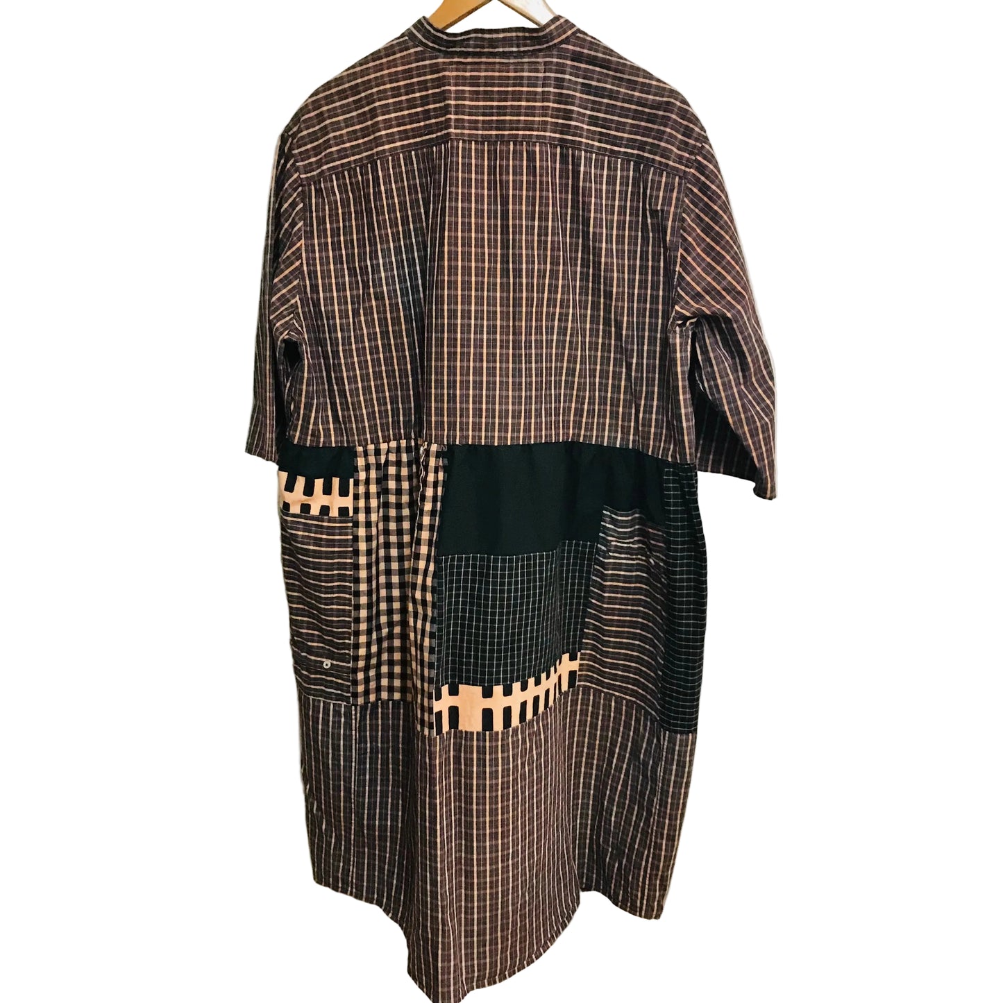 Plaid shirt dress back with black accents on a hanger against a white wall