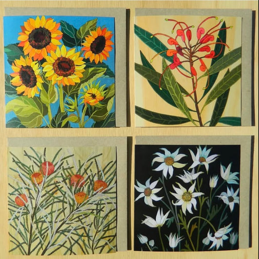 Four floral illustrations on greeting cards on a wooden background