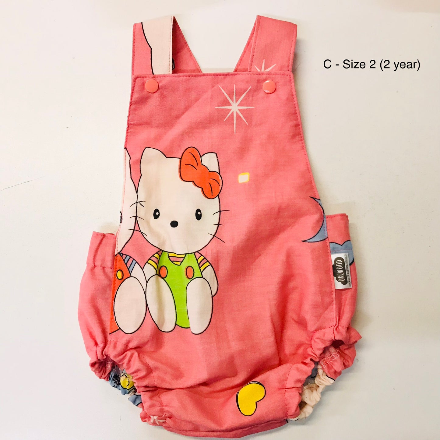 Pink children's romper with cartoon character on a white background