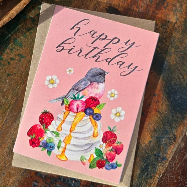 Birthday card with a bird and fruit design on a pink background