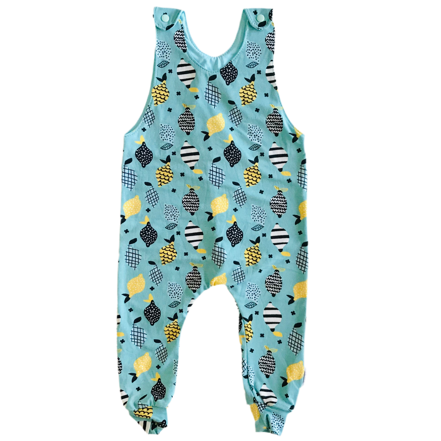 Children's handmade long romper overalls with lemons and lime abstract pattern on a light blue background