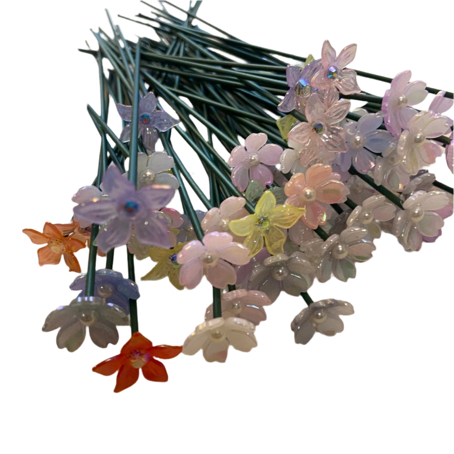 Colorful artificial flowers on a reflective surface with a neutral background