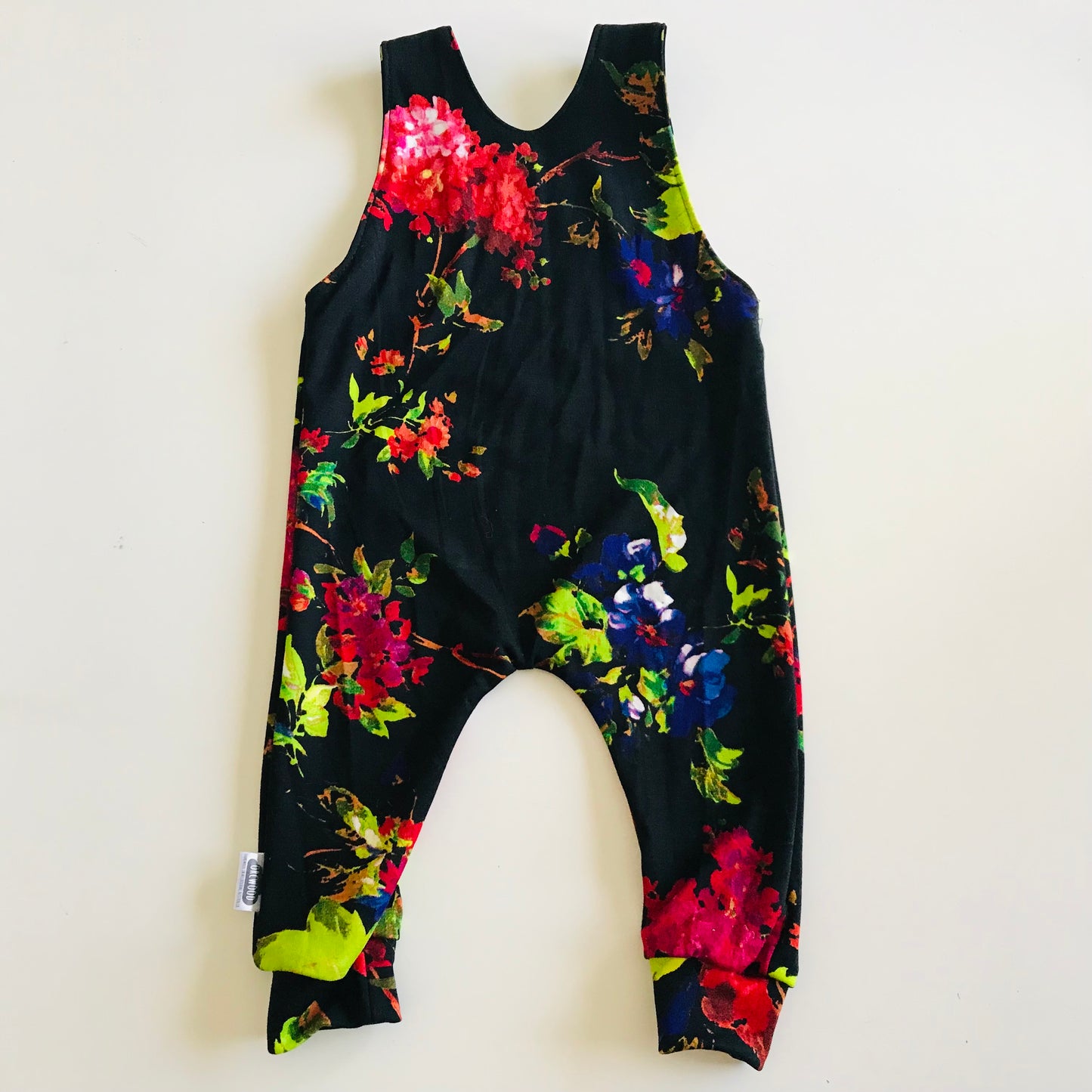 Black overalls with colorful floral pattern on a white background