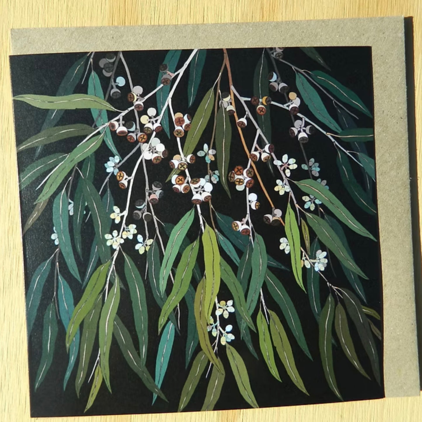 Card with eucalyptus leaves and flowers on a black background