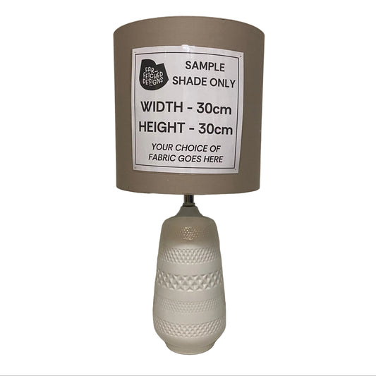 Lamp with a sample shade label on a plain background