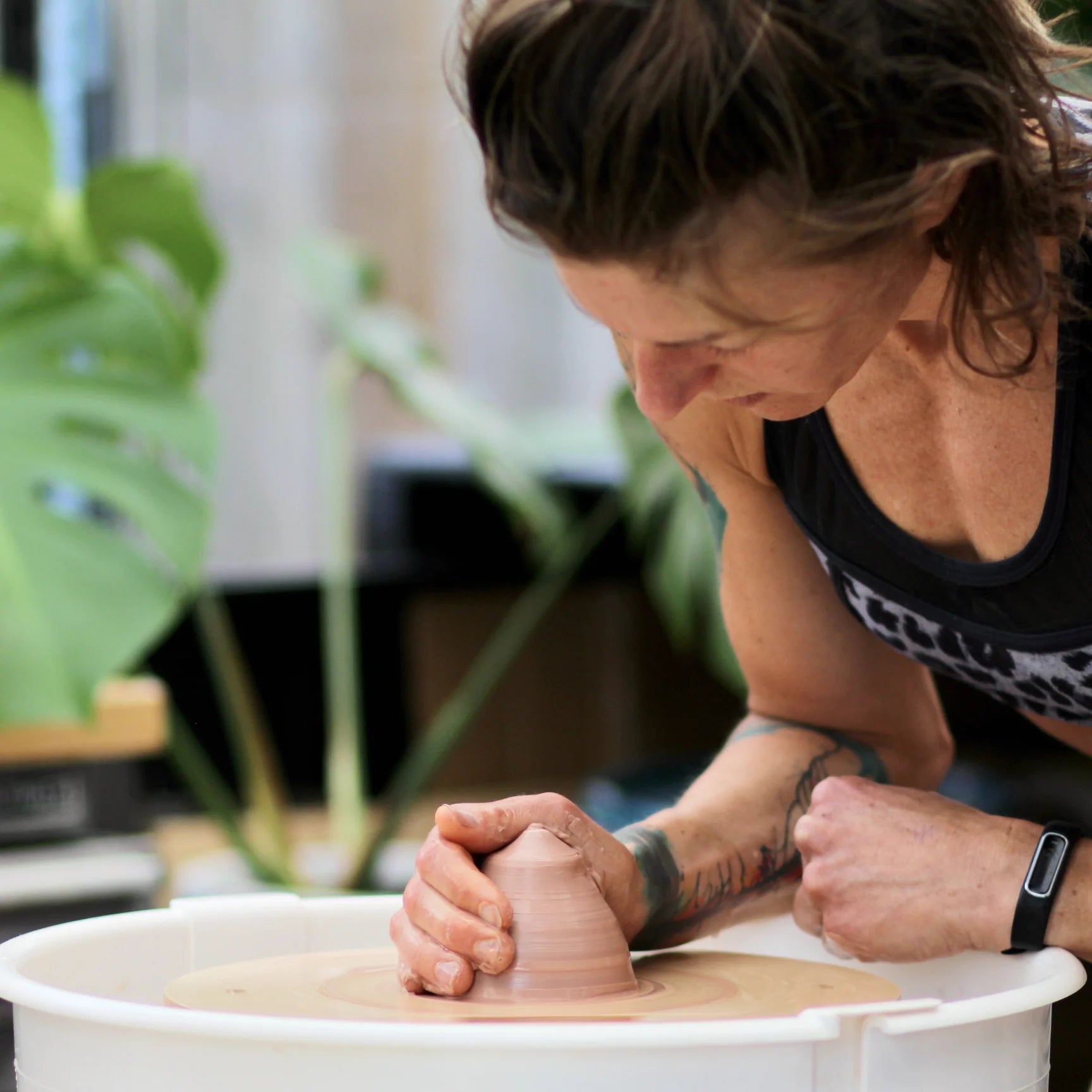 a potter sitting at her pottery wheel