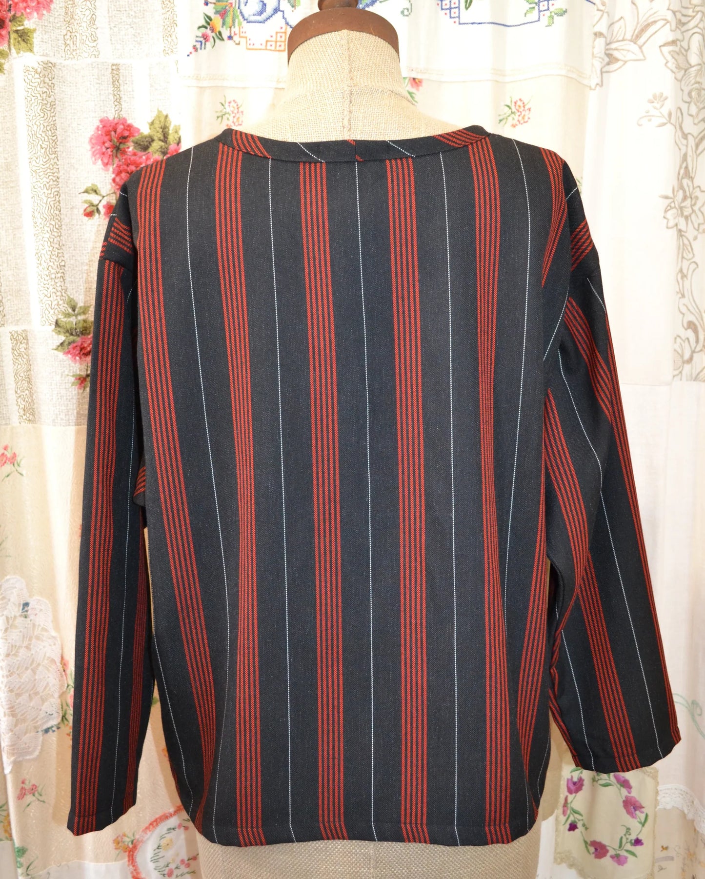 Striped long sleeved kite top on a mannequin against a floral curtain background