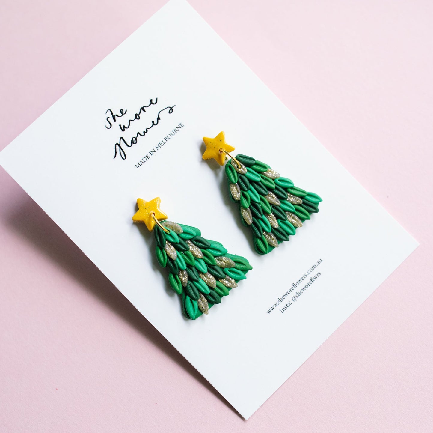 Green Christmas tree earrings on a white card with 'The Paper Flowers' branding on a pink background