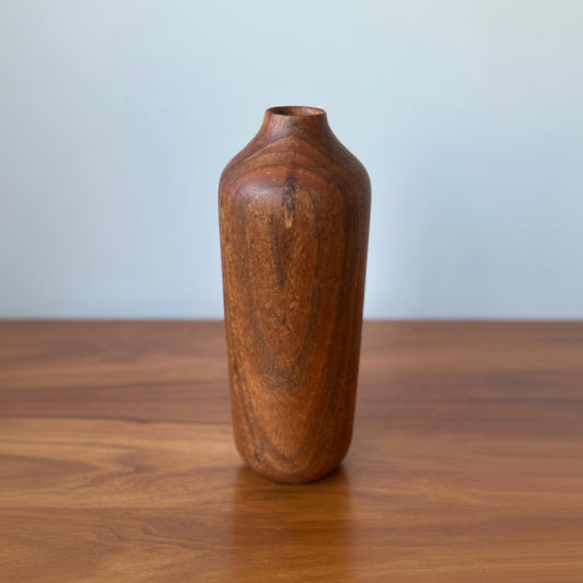 Wooden vase on a wooden surface with a light gray background