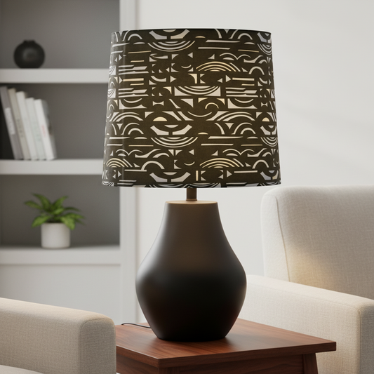 Decorative lamp with a patterned shade on a wooden table in a living room setting.