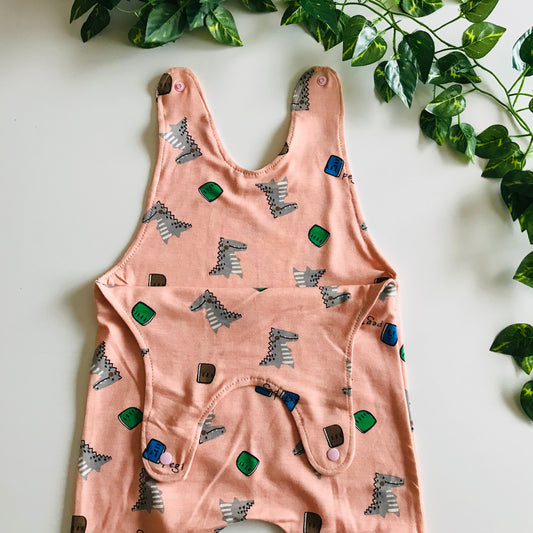 Pink baby romper with animal print on a white background