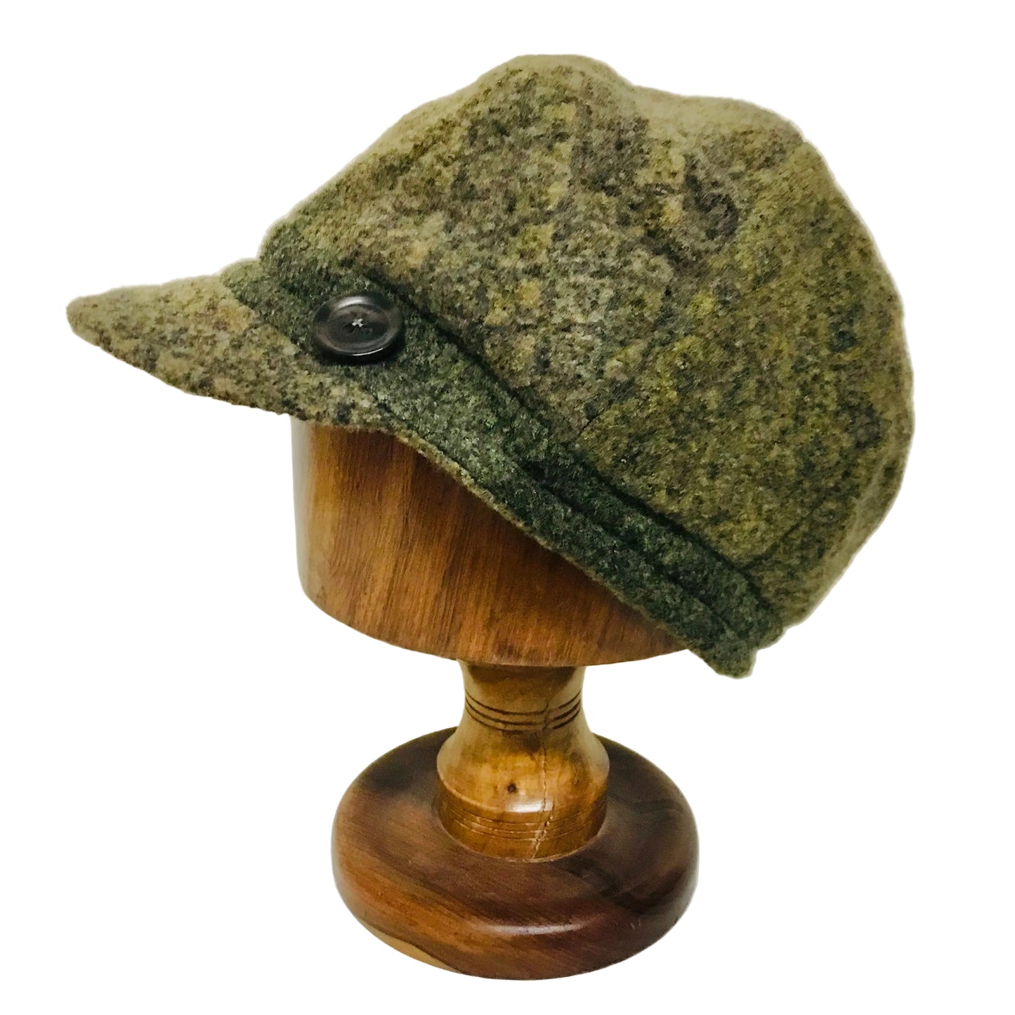 Green patterned cap on a wooden mannequin head against a white background