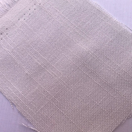 A close-up of a square fabric swatch with frayed edges, showing a light beige woven texture on a pale lavender background.