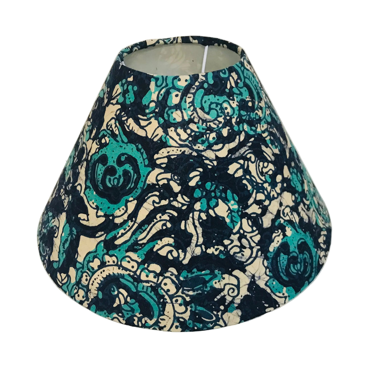 A fabric lampshade with a dark navy blue and teal paisley pattern on a cream background, photographed against a plain white wall.