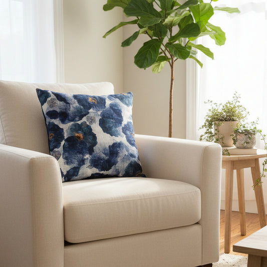 Beige armchair with a blue floral pillow in a bright living room.