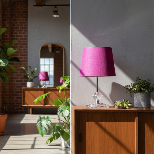 Table lamp with a purple shade and crystal base on a white surface.