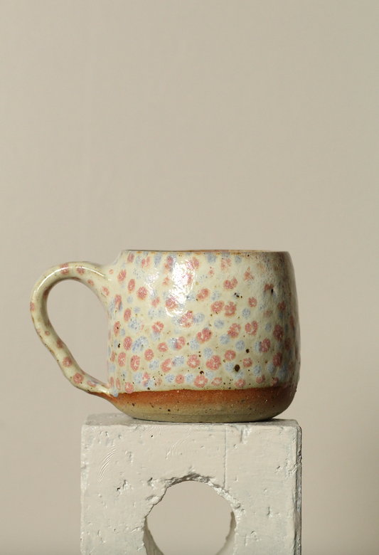 Ceramic mug with floral pattern on a neutral background
