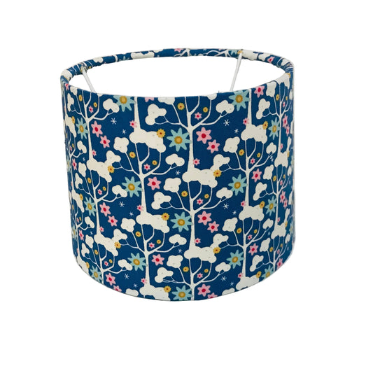 Fabric lampshade with tree and floral pattern on a white background