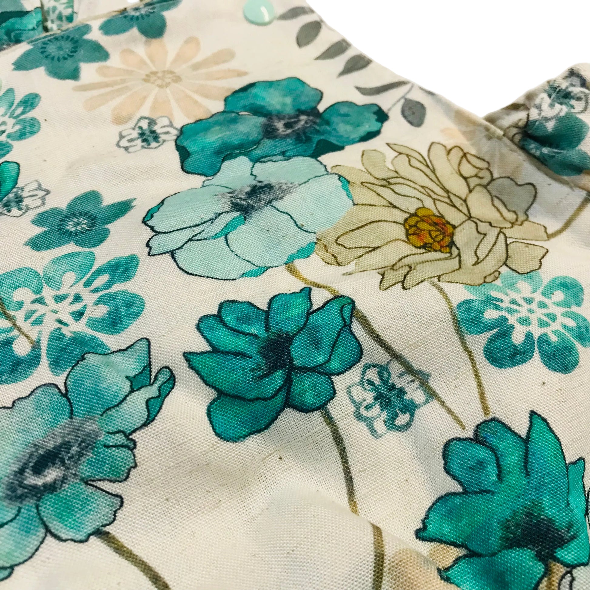 Close-up of a floral fabric with blue and green flowers on a beige background