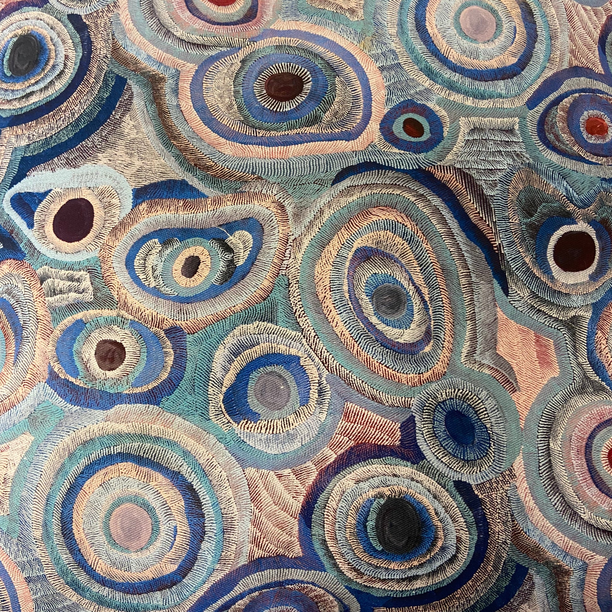 Close-up of a fabric with circular pattern in blue, brown, and beige colors.