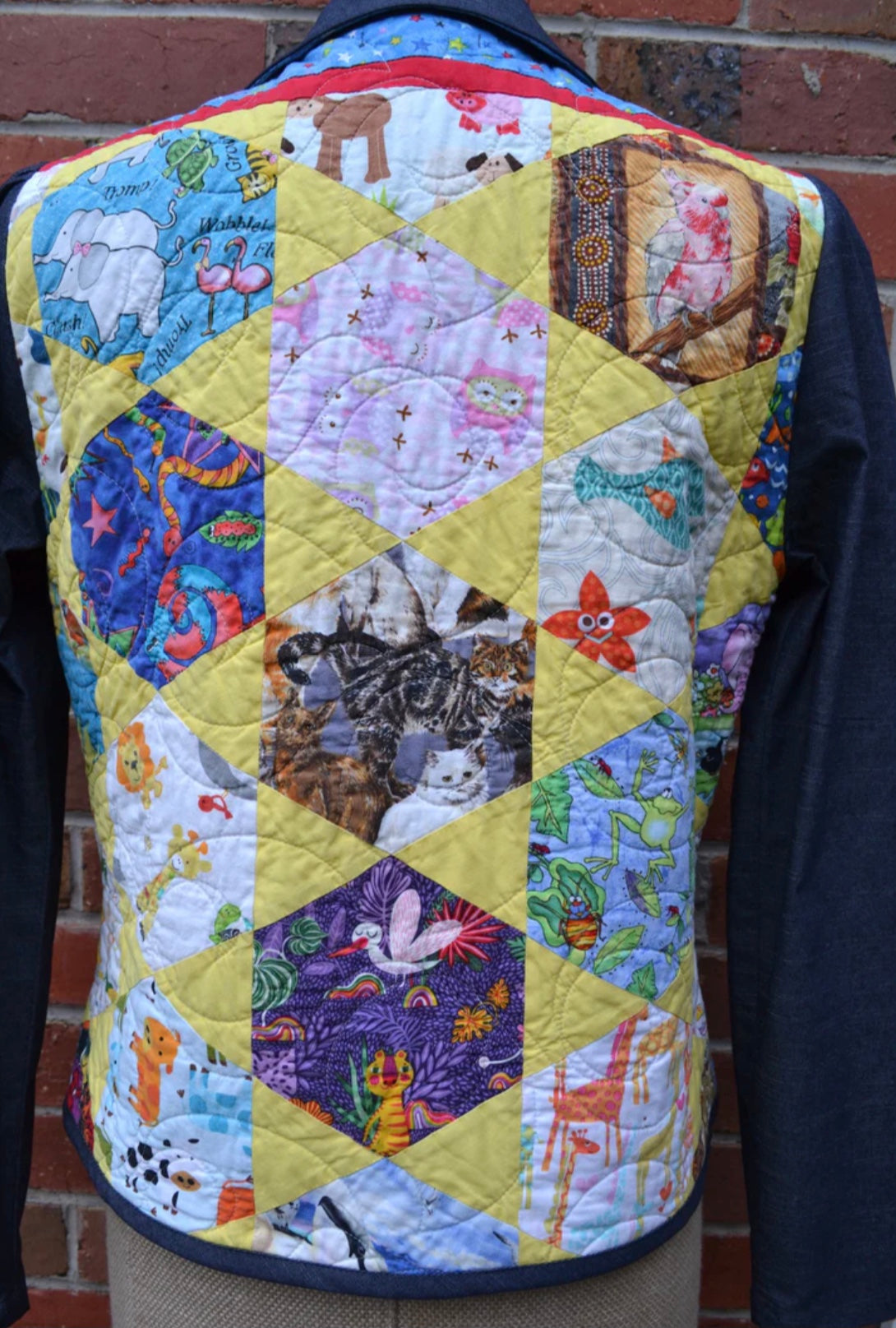 Quilted jacket with colorful patchwork design against a brick wall.